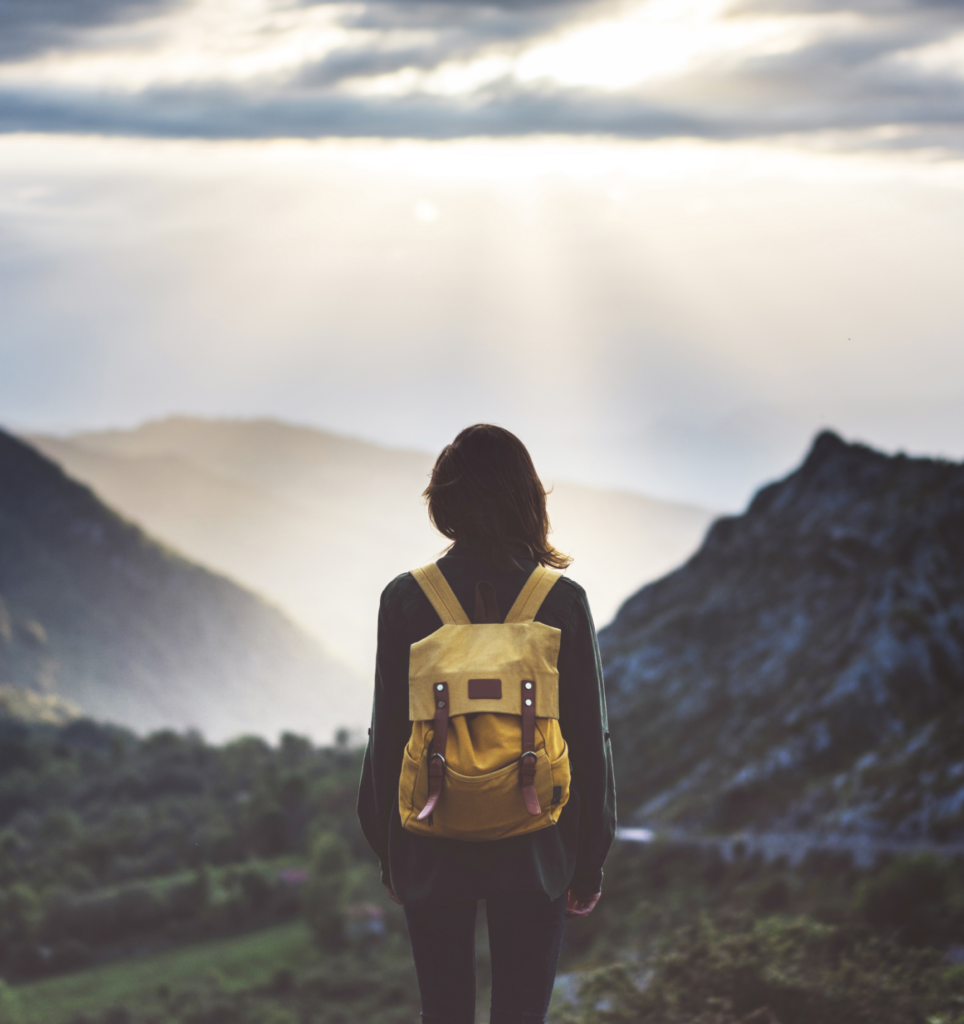 Femme devant une montagne avec un sac a dos